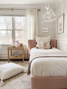 a bedroom with two teddy bears sitting on top of the beds and pillows in front of them