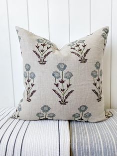 a blue and white pillow sitting on top of a bed