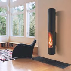 a living room with a chair, fireplace and bookshelf on the wall in front of large windows