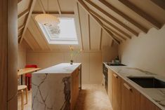 an attic kitchen with white marble counter tops