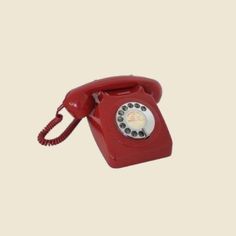 an old fashioned red telephone on a white background