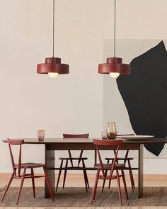 a dining room table with chairs and a large piece of artwork on the wall behind it