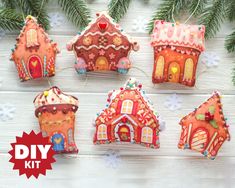 a group of gingerbread house ornaments on a table with pine branches and snowflakes