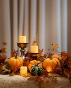 pumpkins and candles are arranged on a table