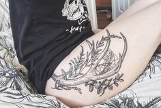 a person laying on top of a bed with a tattoo on their arm and leg