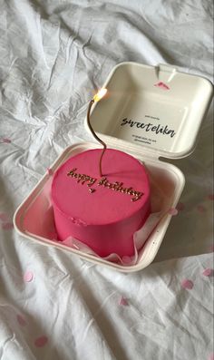 a pink heart shaped cake in a white box