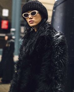 a woman wearing sunglasses and a fur coat