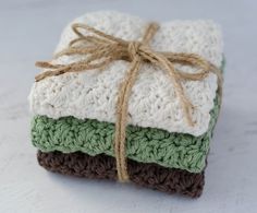 three crocheted coasters tied with twine on top of each other in different colors