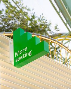 there is a green sign that says more seating on the side of a roller coaster