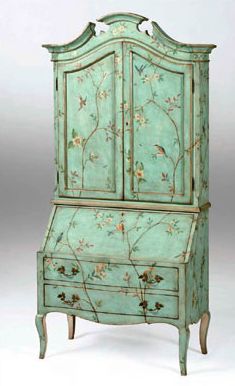 an old green painted armoire with flowers and birds on the front, against a white background