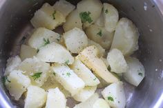 potatoes in a pot with parsley and seasoning sprinkled on the side