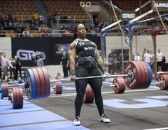 a woman holding a barbell during a competition