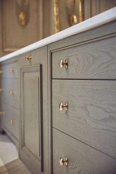 a large gray dresser with gold handles and knobs on it's doors is shown