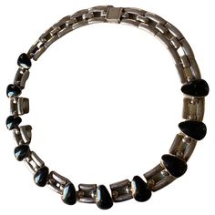 Sterling Silver and Onyx Collar Necklace by Antonio Pineda Designer: Antonio Pineda Maker: Antonio Pineda Circa: 1953-1979 Dimensions: Country of Origin: Taxco, Mexico INV NO: NEC-03 **Antonio Pineda was an internationally renowned Mexican modernist designer/silversmith who was known for his bold and striking designs. He was a member a small cadre of brilliant silversmiths living and working in Taxco, Mexico who became internationally known in the 40s–70s. Born in Taxco in 1919, Antonio Pineda Gomez was third of 10 children. He apprenticed briefly with William Spratling and Mexico City painter/silversmith Valentin Vidauretta before opening his own workshop in 1939. Pineda acknowledges Vidauretta was a great influence in spurring him to develop his own ethos of design. Antonio’s design conc William Spratling Jewelry, The 40s, Collar Necklace, Anton, Signature Style, Mens Bracelet, Concept Design, Onyx, Choker