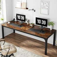 two computer monitors sitting on top of a wooden desk