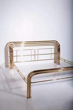 a metal bed frame sitting on top of a white floor in front of a wall