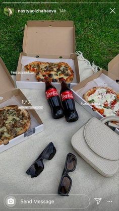 several pizzas and beer are sitting on the ground next to sunglasses, an ice pack, and two soda bottles