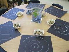 the table is set up with blue placemats and cups filled with green tea