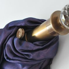 a metal object with a purple cloth draped around it and a crystal knob on the end