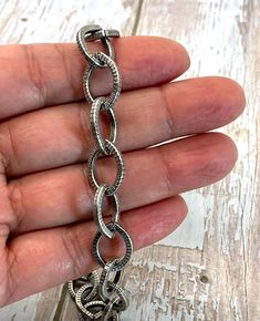 This sturdy 11x9mm oval cable chain is a must-have staple for jewelry designers.  It's perfect for necklaces, bracelets, and for earrings. It will work wonderfully for charm bracelets; choose from our Charms to complete the look.  The chain is strong enough that the links are not soldered and can be opened and closed  (which make great jump rings too🤩) Textured Oval Cable Chain Finish: Antique Silver Links: 11x15mm   Metal: Steel Qty: 1 Foot t will be sent in 1 continuous length when ordering more than 1 foot The photo of the bracelet is for demonstration only and it's NOT included on this listing. 10% off orders of $50 or more 20% off orders of $100 or more Free Shipping on orders of $35 and up NO COUPON NEEDED We offer money back guarantee if you're not happy for any reason, Just return Oval Link Metal Chain Necklace For Jewelry Making, Jewelry Designers, Chain Silver, Diy Jewelry Making, Jump Rings, Jewelry Making Supplies, Charm Bracelets, Cable Chain, Link Chain