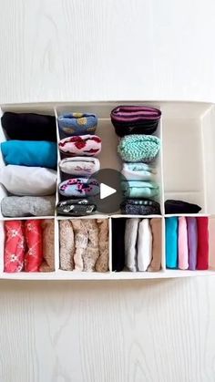 a white shelf filled with lots of different colored clothes and socks on top of it