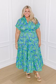 - Pose under the palms in this darling dress! With a botanical print and a timeless design, it is giving tropical vibes. Perfect for a seaside lunch date, this piece brings sunny-chic style to your wardrobe. - Unlined sleek material with a blue, white, black, and green hued botanical print - A collared v-cut neckline - A six buttoned bodice Short sleeves with rolled cuffs - A waistline with an elastic back - A flowy yet flattering silhouette that ends in a midi length hemline Tropical Print V-neck Midi Dress For Garden Party, Vibrant Print V-neck Blue Midi Dress, Long Sweater Dress, The Palms, Lunch Date, Swimwear Dress, Darling Dress, Sparkly Dress, Black Dresses Casual