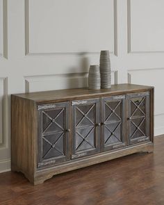 a sideboard with two vases sitting on top of it