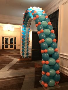 the balloon arch is decorated with orange, blue and white balloons in an elegant room