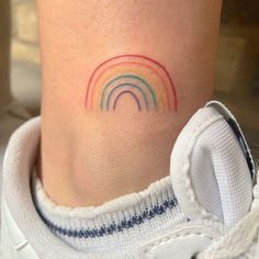 a small rainbow tattoo on the ankle