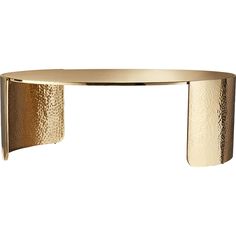 a gold table with curved legs and a circular top that is made out of metal