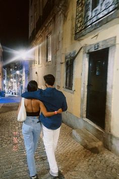 two people walking down the street at night