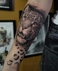 a man's arm with a tattoo of a leopard on it