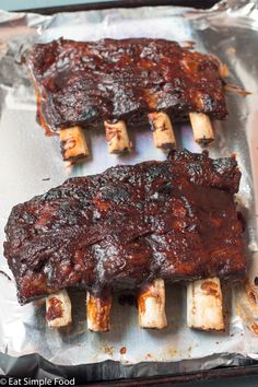 barbecue ribs on tin foil with toothpicks sticking out of the top and bottom