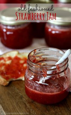 a jar filled with sauce sitting on top of a wooden cutting board next to bread