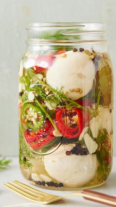 a mason jar filled with vegetables and herbs