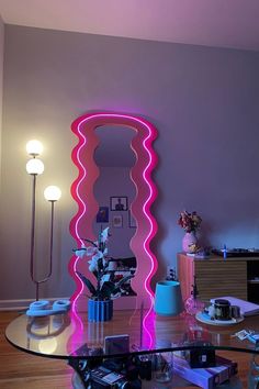 a living room with a large mirror on the wall next to a table and flowers