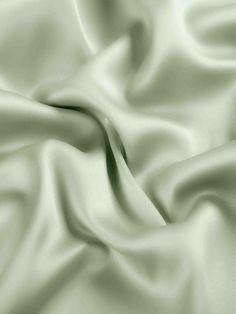 a close up view of a white satin fabric with very soft folds and wrinkles