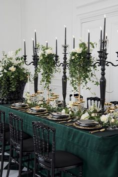 a long table with black chairs and white flowers