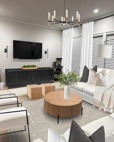 a living room filled with furniture and a flat screen tv mounted to the side of a wall