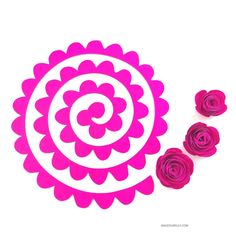 three pink paper flowers sitting next to each other on a white surface with one flower in the middle