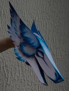 a hand holding a blue and white paper bird