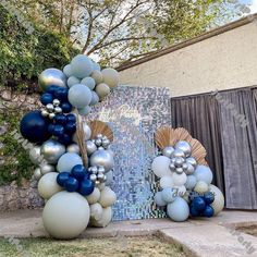 blue and white balloons are on display in front of a wall with a mosaic design