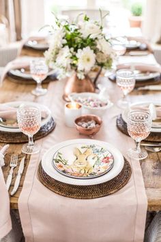 a dining table set with plates and place settings