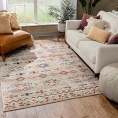 a living room with a couch, chair and rug on the floor in front of a window