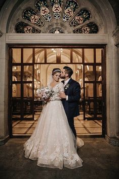 a bride and groom standing in front of an ornate doorway