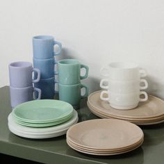 there are many plates and cups on the table