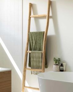 a wooden ladder in the bathroom next to a bathtub