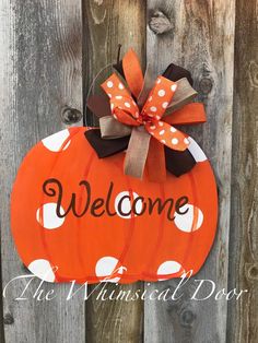 a welcome sign hanging on the side of a wooden fence with polka dots and a bow