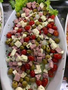 a large platter filled with lots of different types of meats and olives