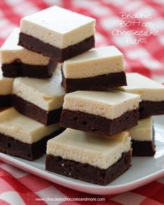 there are brownies and cheesecake bars stacked on a white plate with red and white checkered tablecloth